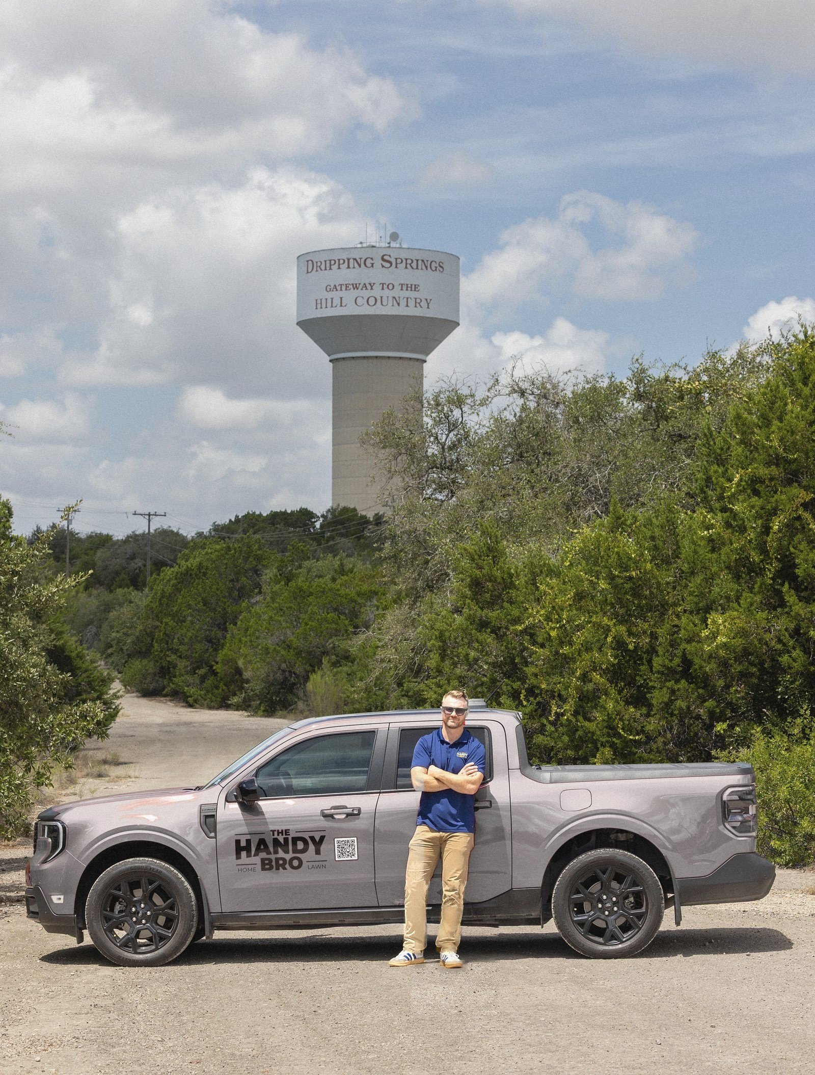 Warren Wiedenfeld of The Handy Bro with the company truck below the Dripping Springs water tower